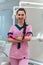 Beautiful dentis in pink uniform smiles on camera