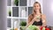 Beautiful dieting woman smiling posing with healthy cocktail with mint and lemon in kitchen