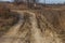 Beautiful dirt and gravel dust road path on the highland of Europe. A muddy rough terrain for an extreme 4WD 4x4 car. Sand dune