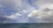 Beautiful double rainbow over ocean water with storm clouds in the sky.