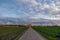 Beautiful dramatic orange and blue cloud and sky after storm over agricultural field.