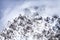 Beautiful dramatic snowy Caucasus mountain peaks in clouds. Scenic winter landscape