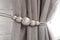 Beautiful draped window curtain with tieback in room