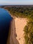 Beautiful drone areal photography view of large dune and pine forest near river Lielupe. Photo taken on sunset