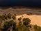 Beautiful drone areal photography view of large dune and pine forest near river Lielupe. Photo taken on sunset