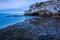 A beautiful early evening seascape with dramatic rocks and misty waves in the foreground