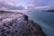 A beautiful early morning seascape with rocks and misty waves in the foreground