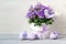 Beautiful easter composition in pastel colors with Campanula flowers, Easter eggs and ceramic bird