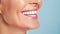 Beautiful elder womans smile with healthy white, straight teeth close-up on light background with space for text