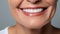 Beautiful elder womans smile with healthy white, straight teeth close-up on light background with space for text