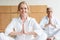 beautiful elderly woman performing namaste gesture and smiling at camera while practicing yoga