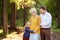 Beautiful eldery woman and her grown ups son, and her little grandson tenderly embracing together in park