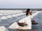 Beautiful and elegant bride with long white dress walking in salt field