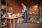 Beautiful elegant Caucasian female artisan wearing apron squeezing clay in pottery workshop