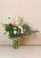 A beautiful elegant designer airy winter bouquet of flowers with Christmas decorations stands on the table. It is composed of