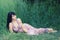 Beautiful elegant girl lying in high grass in summer