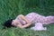 Beautiful elegant girl sleeping in high grass in spring