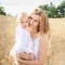 Beautiful elegant mother and little daughter wheat field, family