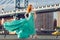 Beautiful elegant red haired woman standing near Manhattan Bridge in New York City wearing long green dress.