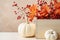 Beautiful elegant Thanksgiving autumn decorative composition with white pumpkins orange maple leaves branches with red berries.