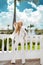 Beautiful, elegant woman in a white suit posing on the background of the caribbean palms