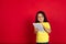 Beautiful emotional little girl isolated on red background. Half-lenght portrait of happy child gesturing