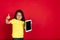 Beautiful emotional little girl isolated on red background. Half-lenght portrait of happy child gesturing