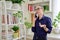 Beautiful emotional woman in her 30s talking on a cell phone, standing in her room at home