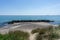 Beautiful empty beach behind sand dunes with rocky storm groins to protect from erosion and a rescue station