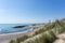 Beautiful empty beach behind sand dunes with rocky storm groins to protect from erosion and the Skagen lighthouse in the