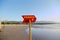 Beautiful empty beach with a red sign with word danger.