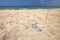 Beautiful empty beach, small pile of rubbish tangled plastic ropes on fine sand. Ocean littering concept. Karpass, Northern