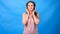 Beautiful Energy Girl with headphones listening to music on a blue background in the studio