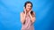 Beautiful Energy Girl with headphones listening to music on a blue background in the studio