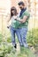 Beautiful engaged couple watering plants in the garden