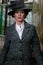 Beautiful english woman dressed in 1920s costume walking on railway platform with train in background