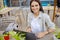 Beautiful entrepreneur using laptop during lunch in outdoor cafe, elegant businesswoman holding coffee cup working in city street.