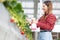 Beautiful entrepreneur young asian woman standing and watering strawberry plants in farm at greenhouse.