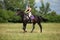 Beautiful equestrian girl bareback ride her horse in woods glade