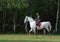 Beautiful equestrian sports girl ride her horse in woods glade