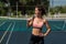 Beautiful European woman posing on a tennis court and holding a rocket