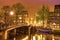 Beautiful evening landscape on the canal in Amsterdam, Netherlands, Europe. Bridge and illumination