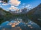 Beautiful evening landscape with glacier reflection in water surface of mountain lake. Snowy mountain reflected in clear water of