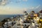 Beautiful evening light scene of Oia white building townscape and windmill along island mountain, vast Aegean sea, soft cloud