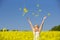 A beautiful excited girl throwing flowers in a field of yellow flowers