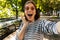 Beautiful excited shocked woman outdoors take a selfie by camera.