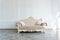 Beautiful expensive beige sofa against a white wall in an empty room