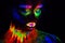 Beautiful extraterrestrial model woman in neon light. It is portrait of beautiful model with fluorescent make-up, Art