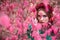 A beautiful and fabulous girl in a pink foliage with red wreath