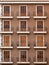 Beautiful facade of a brick building with balconies. Classic European style with shutters